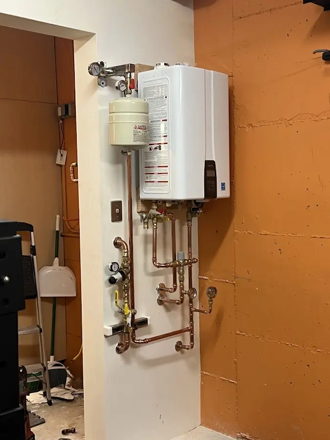 Plumbing technician inspecting water heater connections in Rosendale